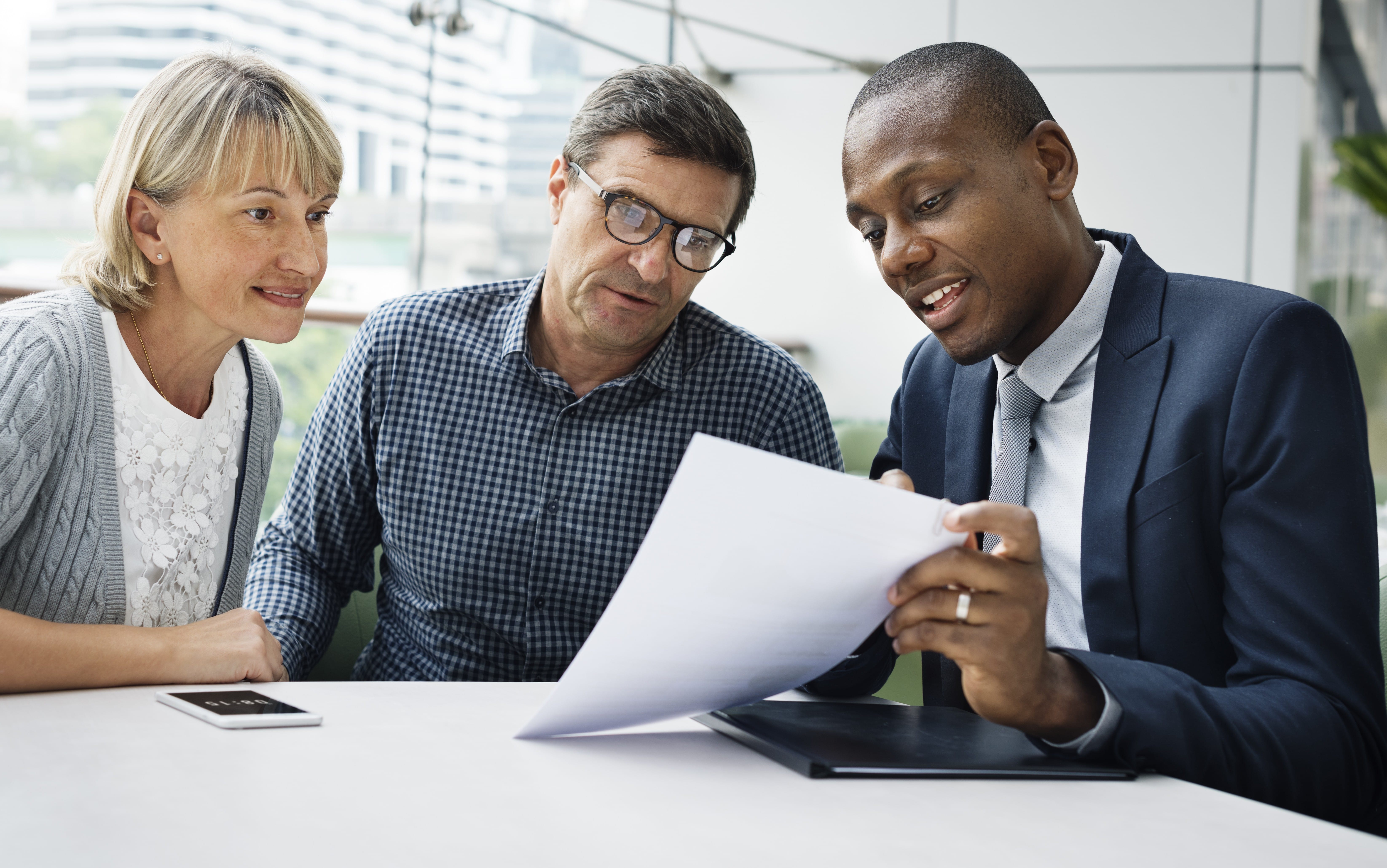 Couples Reviewing a Report with a Banker Couples Reviewing a Report with a Banker
